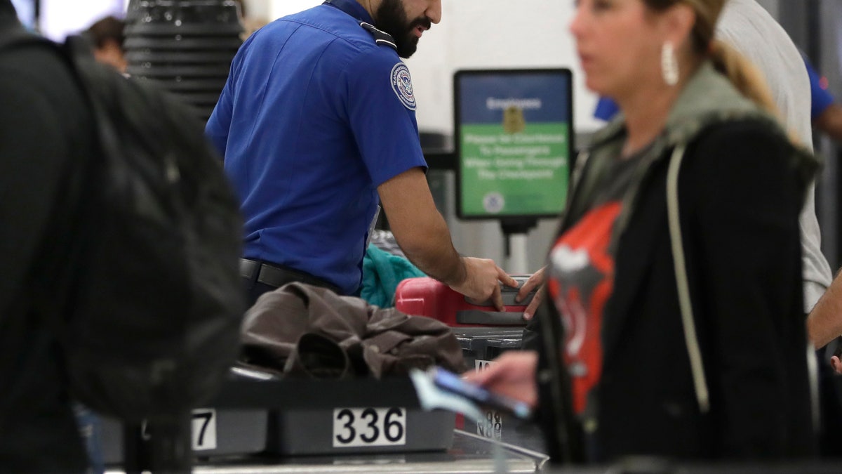 A Transportation Security Administration officer works at a checkpoint at Miami International Airport, Sunday, Jan. 6, 2019, in Miami. The TSA acknowledged an increase in the number of its employees calling off work during the partial government shutdown.