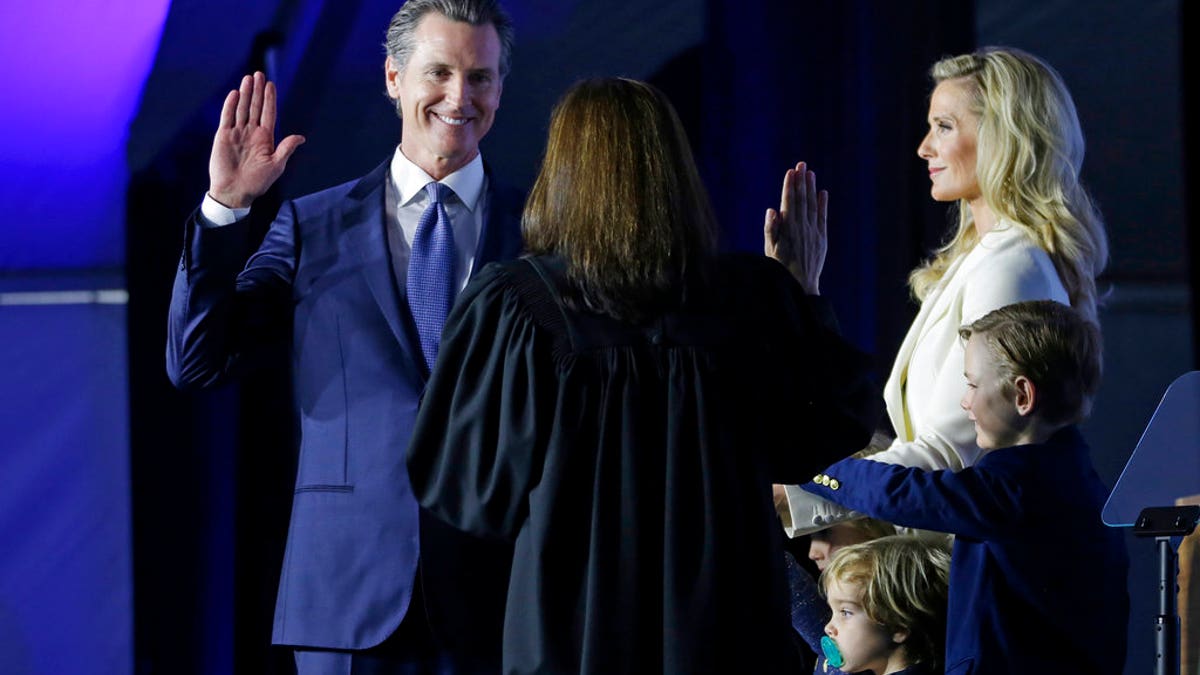 California Governor Gavin Newsom takes the oath of office from state Supreme Court Chief Justice Tani Gorre Cantil-Sakauye during his inauguration Monday, Jan. 7, 2019, in Sacramento, Calif. Looking on is Newsom's wife, Jennifer Siebel Newsom and their sons, Dutch, second from right, and Hunter, right. (AP Photo/Rich Pedroncelli)