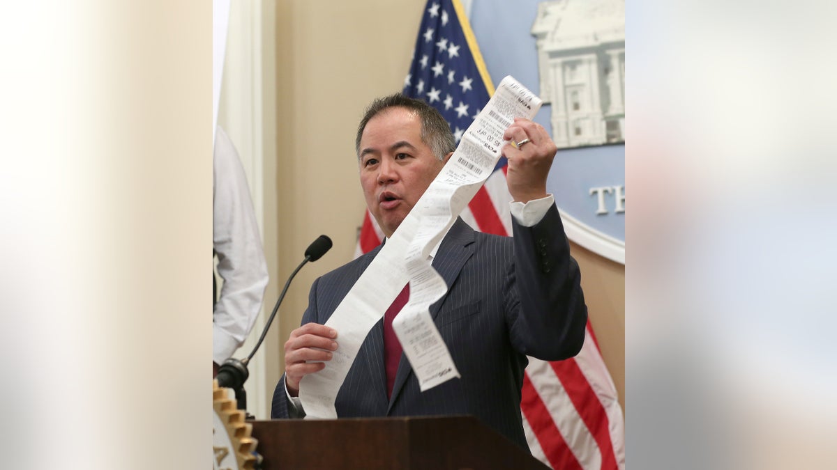 Assemblyman Phil Ting, D-San Francisco, displays a long paper receipt as he discusses his bill to require businesses to offer electronic receipts, Tuesday, Jan. 8, 2019, in Sacramento, Calif.