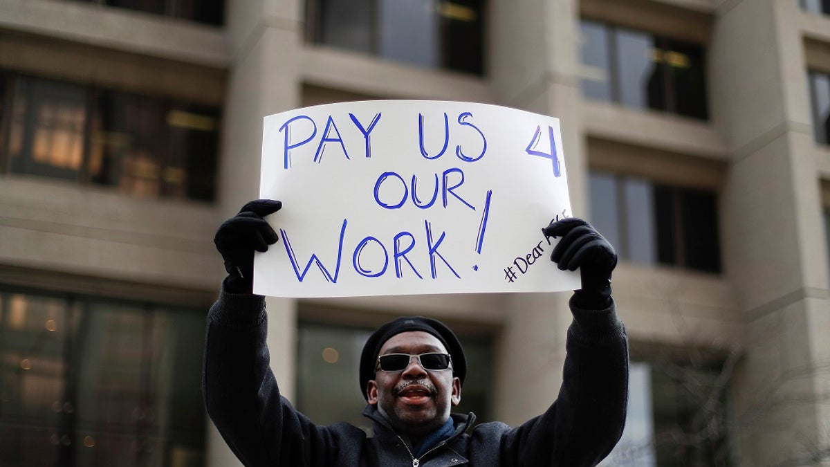 Christopher Belcher, a Department of Veterans Affairs employee, holds a sign during a rally to call for an end to the partial government shutdown, in Detroit, Thursday, Jan. 10, 2019. (Associated Press)