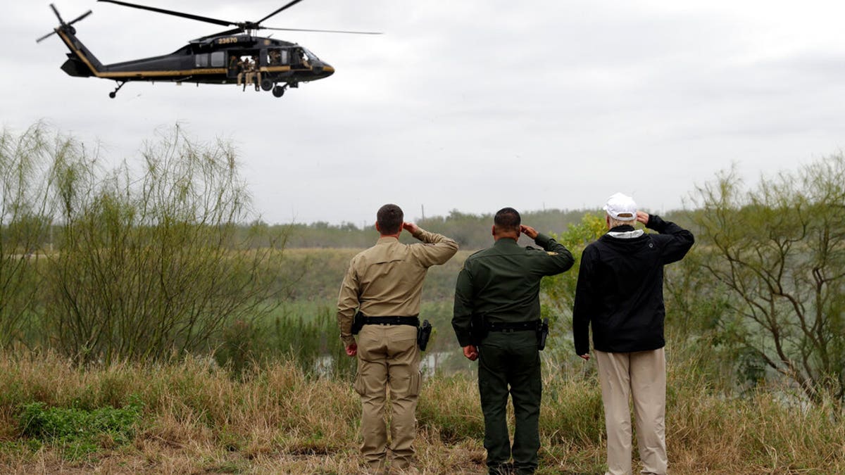 President Donald Trump salutes as he tours the U.S. border with Mexico at the Rio Grande on the southern border, Thursday, Jan. 10, 2019, in McAllen, Texas. (AP Photo/ Evan Vucci)