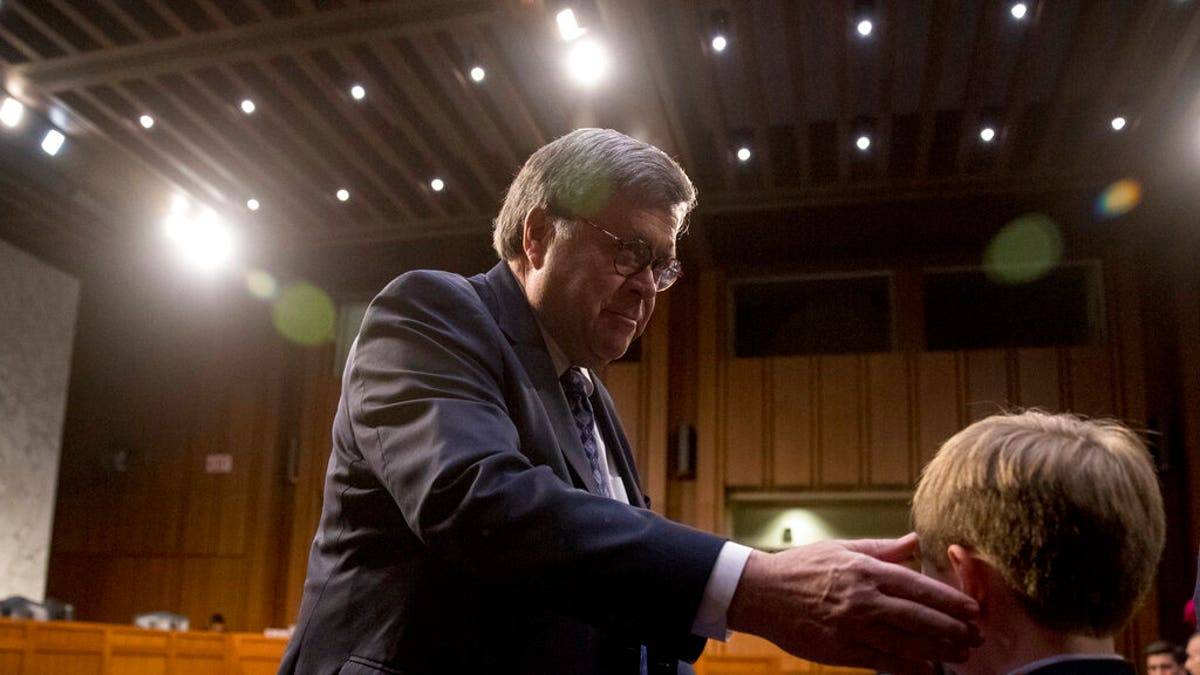 Attorney General nominee William Barr thanks his grandson Liam Daly, right, for a mint as he returns from a break in testimony at a Senate Judiciary Committee hearing on Capitol Hill in Washington, Tuesday, Jan. 15, 2019. As he did almost 30 years ago, Barr is appearing before the Senate Judiciary Committee to make the case he's qualified to serve as attorney general. (AP Photo/Andrew Harnik)