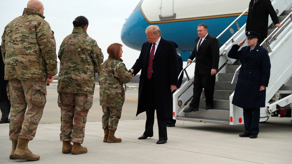 President Donald Trump greets Col. Dawn C. Lancaster, Commander Air Force Mortuary Affairs, at Dover Air Force Base, Del., Saturday, Jan. 19, 2019, as he arrives to pay tribute to the four Americans killed in a suicide bomb attack in Syria as their remains are returned 
