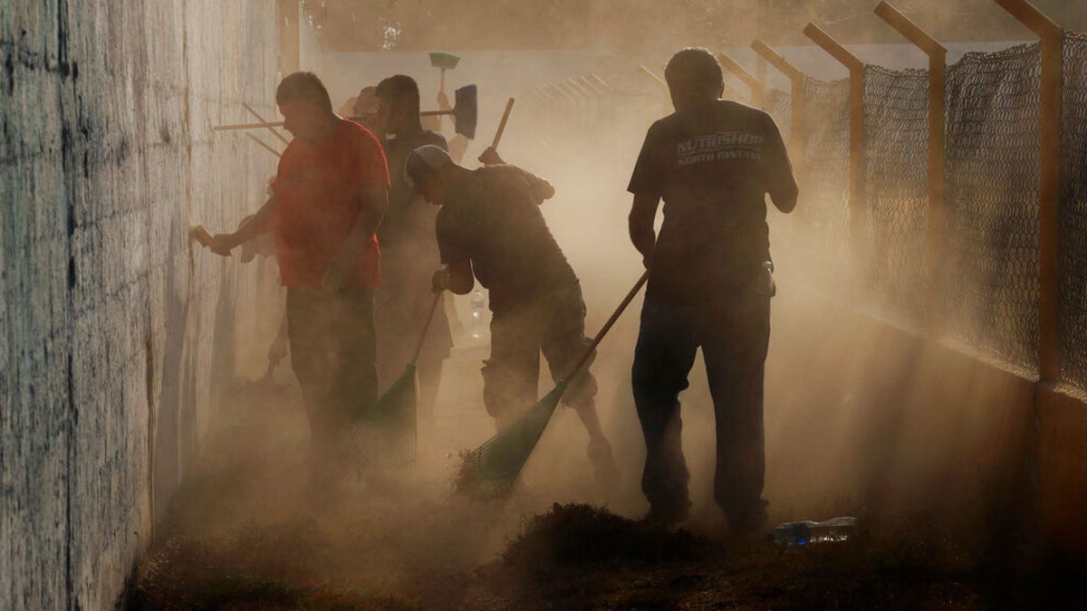 Central American migrants, who received humanitarian visas from Mexico, working for pay as they clean a public sports stadium which is being prepared to use as a shelter for migrants who enter Ciudad Hidalgo, Mexico, on Monday. (AP Photo/Marco Ugarte)