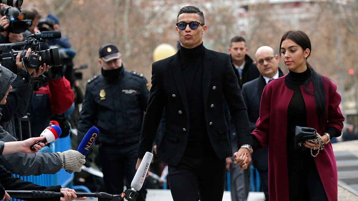 Cristiano Ronaldo arrives at the court in Madrid on Tuesday, Jan. 22, 2019. Cristiano Ronaldo is expected to plead guilty to tax fraud. The Juventus forward arrived in a black van, walked up some stairs leading to the court house and stopped to sign an autograph. The charges stem from his days at Real Madrid. 