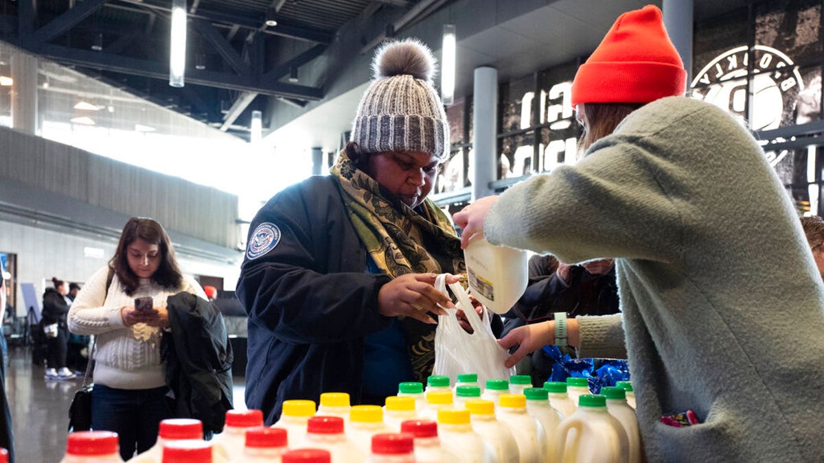 TSA worker Amelia Williams is given a bottle of milk at a food bank for government workers affected by the shutdown, Tuesday, Jan. 22, 2019, in the Brooklyn borough of New York. (AP Photo/Mark Lennihan)