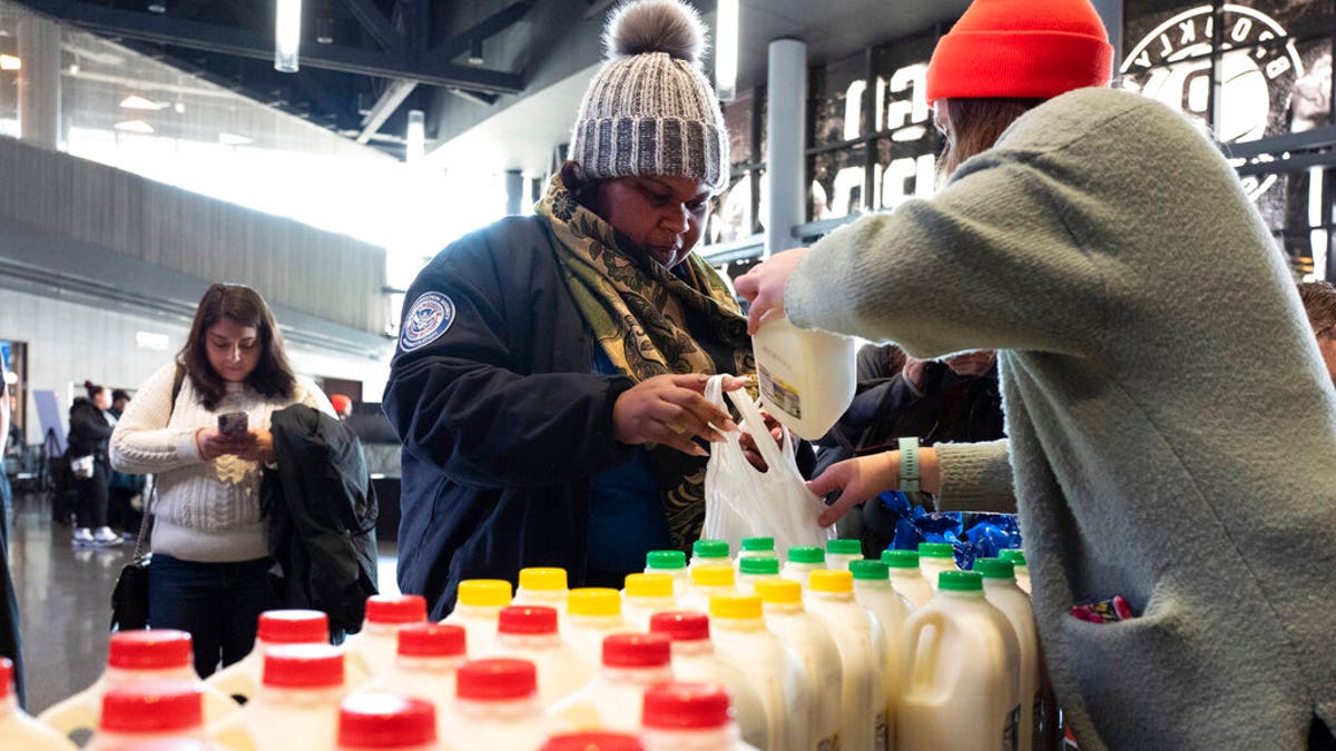 TSA worker Amelia Williams is given a bottle of milk at a food bank for government workers affected by the shutdown, Tuesday, Jan. 22, 2019, in the Brooklyn borough of New York. (AP Photo/Mark Lennihan)