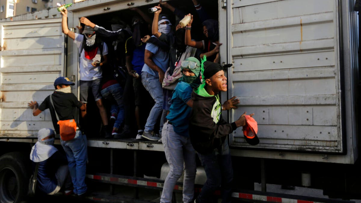 Anti-government protesters seize a state vehicle to use as transport, after a rally demanding the resignation of President Nicolas Maduro in Caracas, Venezuela, Wednesday, Jan. 23, 2019. The head of Venezuela's opposition-run congress declared himself interim president at the rally, until new elections can be called.(AP Photo/Fernando Llano)