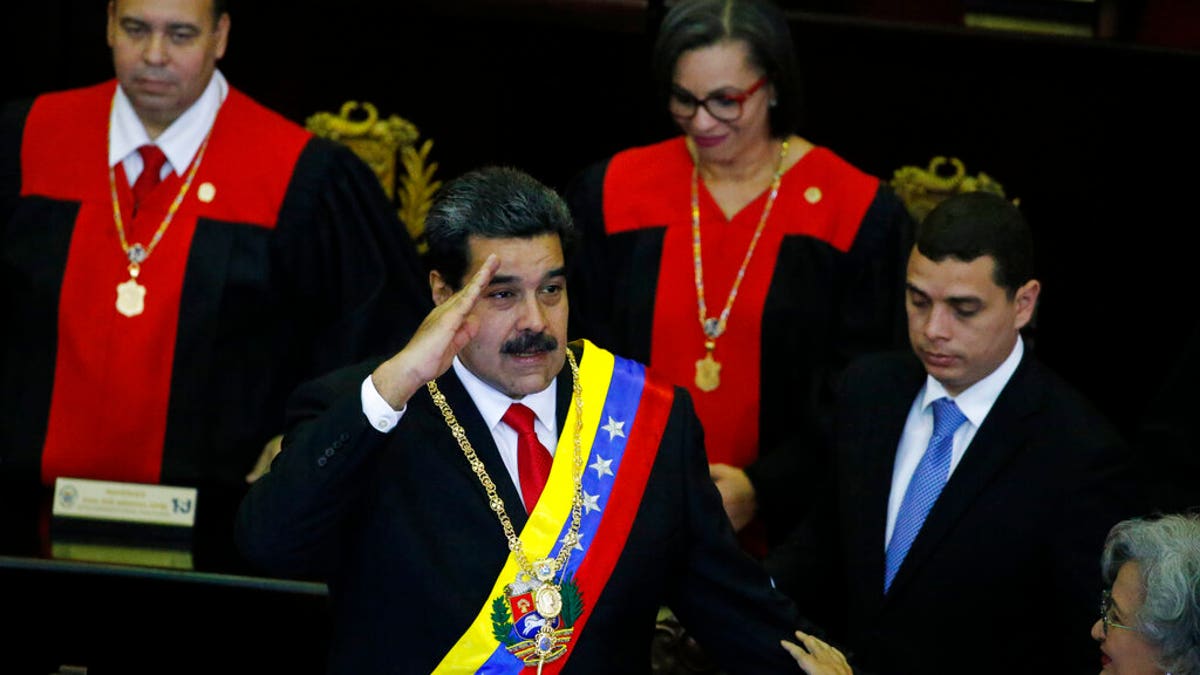Venezuelan President Nicolas Maduro salutes as he arrives to the Supreme Court for an annual ceremony that marks the start of the judicial year in Caracas, Venezuela, Thursday, Jan. 24, 2019. Venezuelans are heading into uncharted political waters after the young leader of a newly united opposition claimed Wednesday to hold the presidency and Maduro dug in for a fight with the Trump administration. (AP Photo/Ariana Cubillos)
