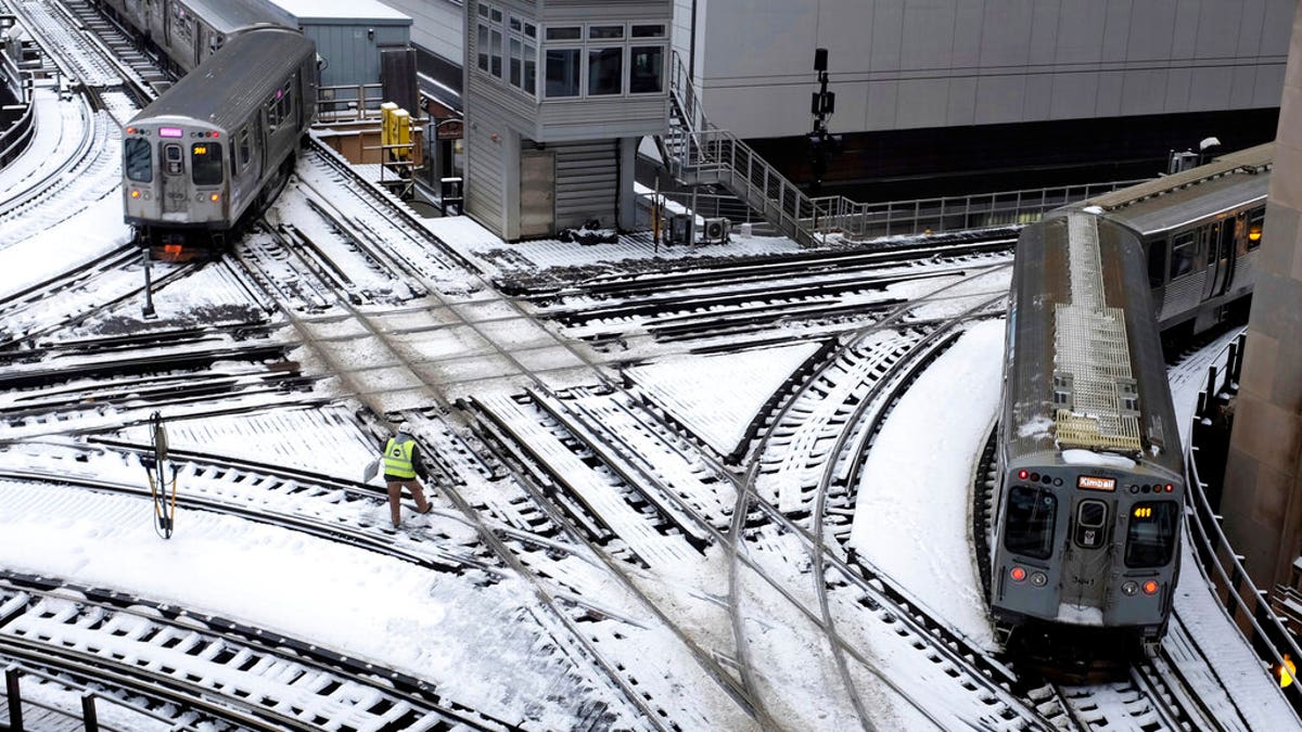 Chicago's L trains move along snow-covered tracks. (Associated Press)