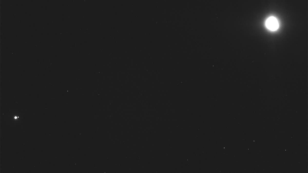 This image captured on Dec. 19, 2018, by a camera on the Osiris-Rex spacecraft shows the asteroid Bennu, top right, about 27 miles from the spacecraft, and the Earth and moon, bottom left, more than 70 million miles away. (NASA/Goddard/University of Arizona/Lockheed Martin Space via AP)