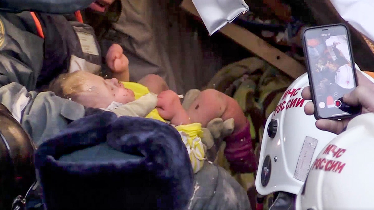 This photo provided by the Russian Emergency Situations Ministry taken from Television footage shows rescuers saving a 10-month-old baby Tuesday after a building collapse in Magnitigorsk on New Year's Eve. (Russian Ministry for Emergency Situations photo via AP)