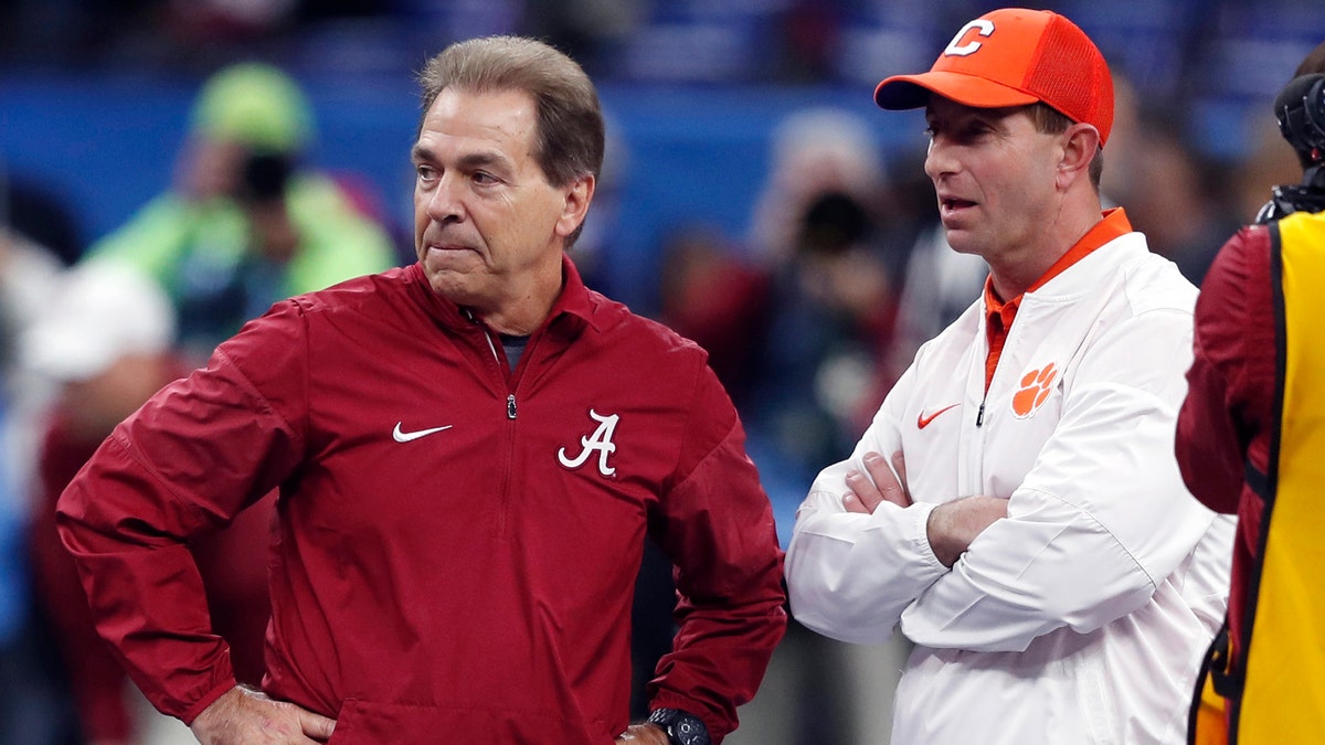 FILE - In this Jan. 1, 2018, file photo, Alabama head coach Nick Saban, left, and Clemson head coach Dabo Swinney talk before the Sugar Bowl semifinal playoff game for the NCAA college football national championship in New Orleans.