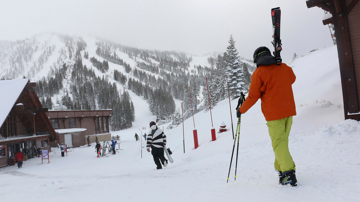 FILE - In this Nov. 29, 2018, file photo, skiers and snowboarders walk to the lifts at Mt. Rose Ski Tahoe near Reno, Nev.