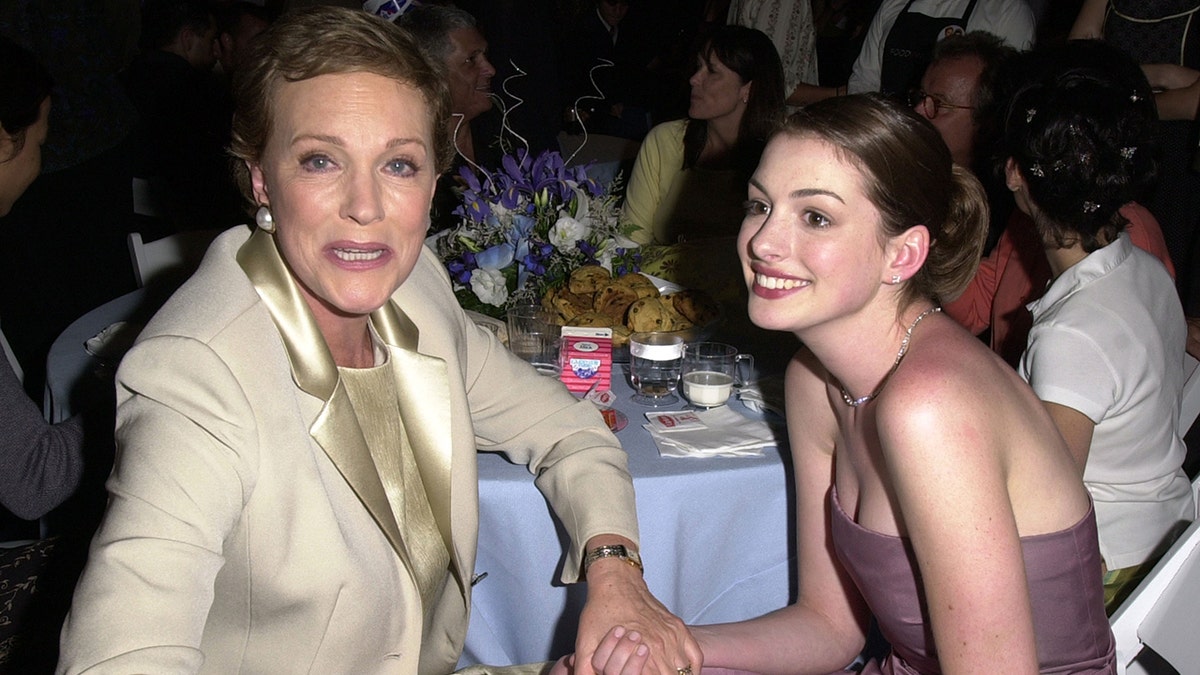 Julie Andrews, left, clutches Anne Hathaway's hand at an after following the premiere of "The Princess Diaries" at El Capitan Theatre on July 29, 2001, in Hollywood, Calif.