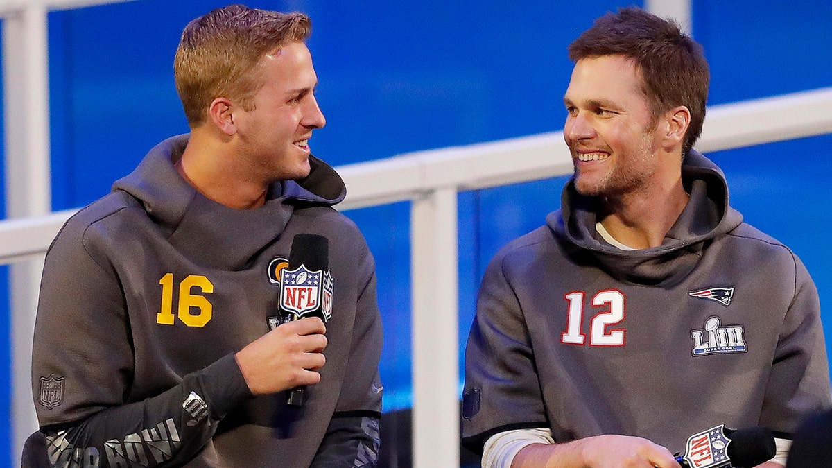Los Angeles Rams' Jared Goff talks to New England Patriots' Tom Brady during Opening Night for the NFL Super Bowl 53 football game Monday, Jan. 28, 2019, in Atlanta. (AP Photo/John Bazemore)
