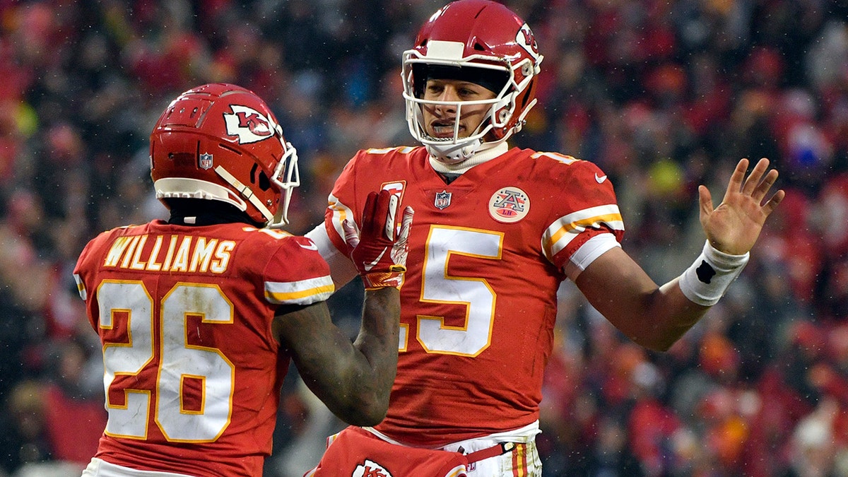 Kansas City Chiefs quarterback Patrick Mahomes (15) celebrates a touchdown with running back Damien Williams (26) during the first half of an NFL divisional football playoff game against the Indianapolis Colts.