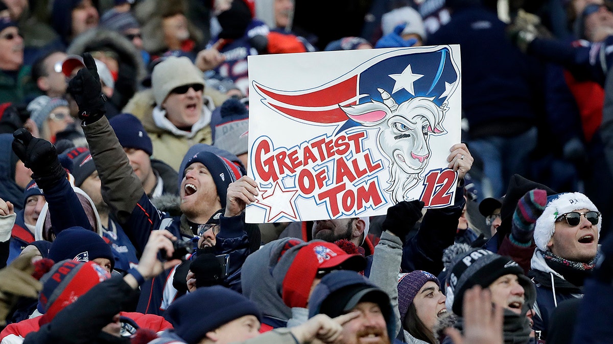 Fans cheer and hold a sign referring to New England Patriots quarterback Tom Brady. (AP Photo/Elise Amendola)