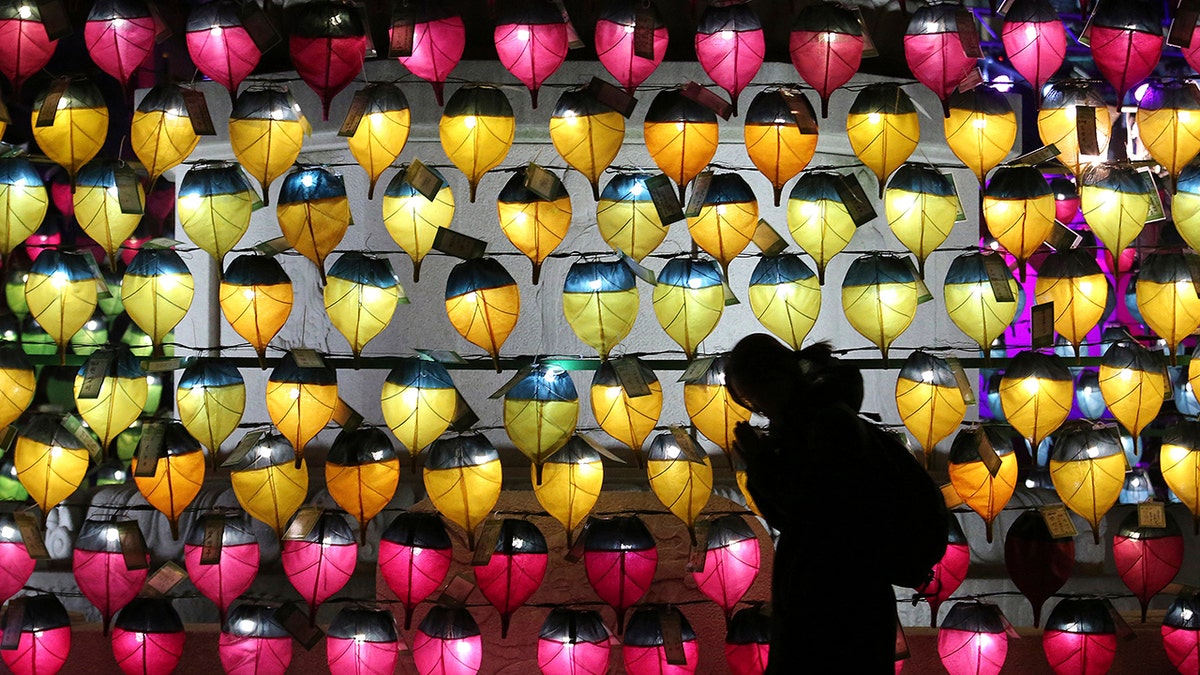 A woman prays in front of a wall of lanterns to celebrate the New Year at the Jogyesa Buddhist temple in Seoul, South Korea, Monday, Dec. 31, 2018. (AP Photo/Ahn Young-joon)