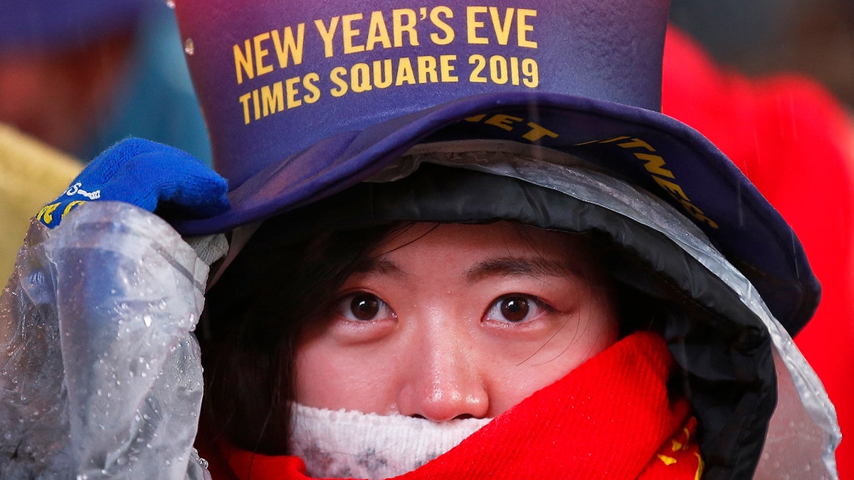 A reveler adjusts her hat as she waits in Times Square in New York on Monday, Dec. 31, 2018, while taking part in a New Year's Eve celebration. (AP Photo/Adam Hunger)