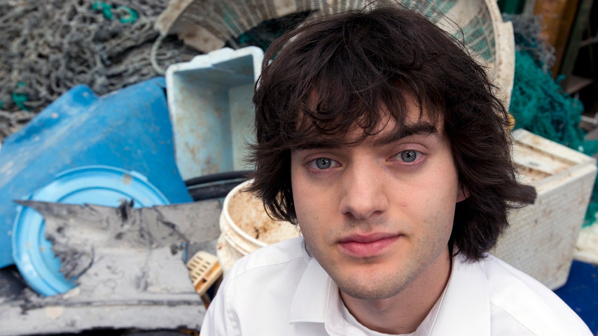 FILE - In this May 11, 2017, file photo, Dutch innovator Boyan Slat poses for a portrait next to a pile of plastic garbage prior to a press conference in Utrecht, Netherlands. (AP Photo/Peter Dejong, File)