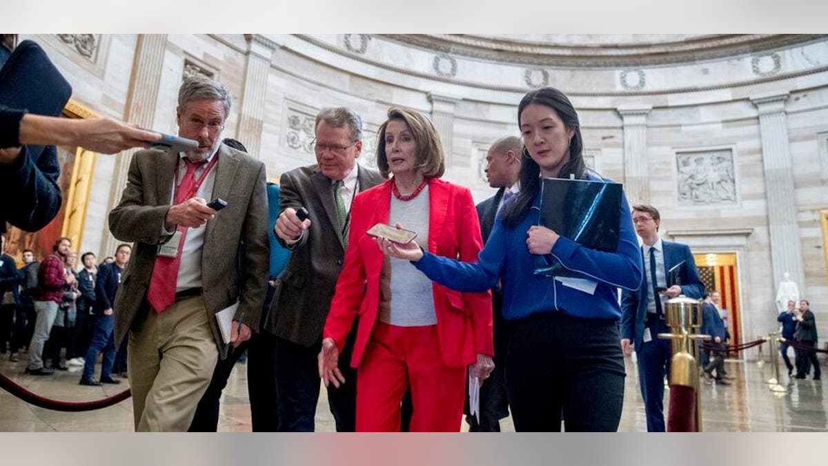 House Speaker Nancy Pelosi of Calif., center, speaks to reporters as she leaves an event with furloughed federal workers amid the partial government shutdown, Wednesday, Jan. 16, 2019, on Capitol Hill in Washington. (AP Photo/Andrew Harnik)