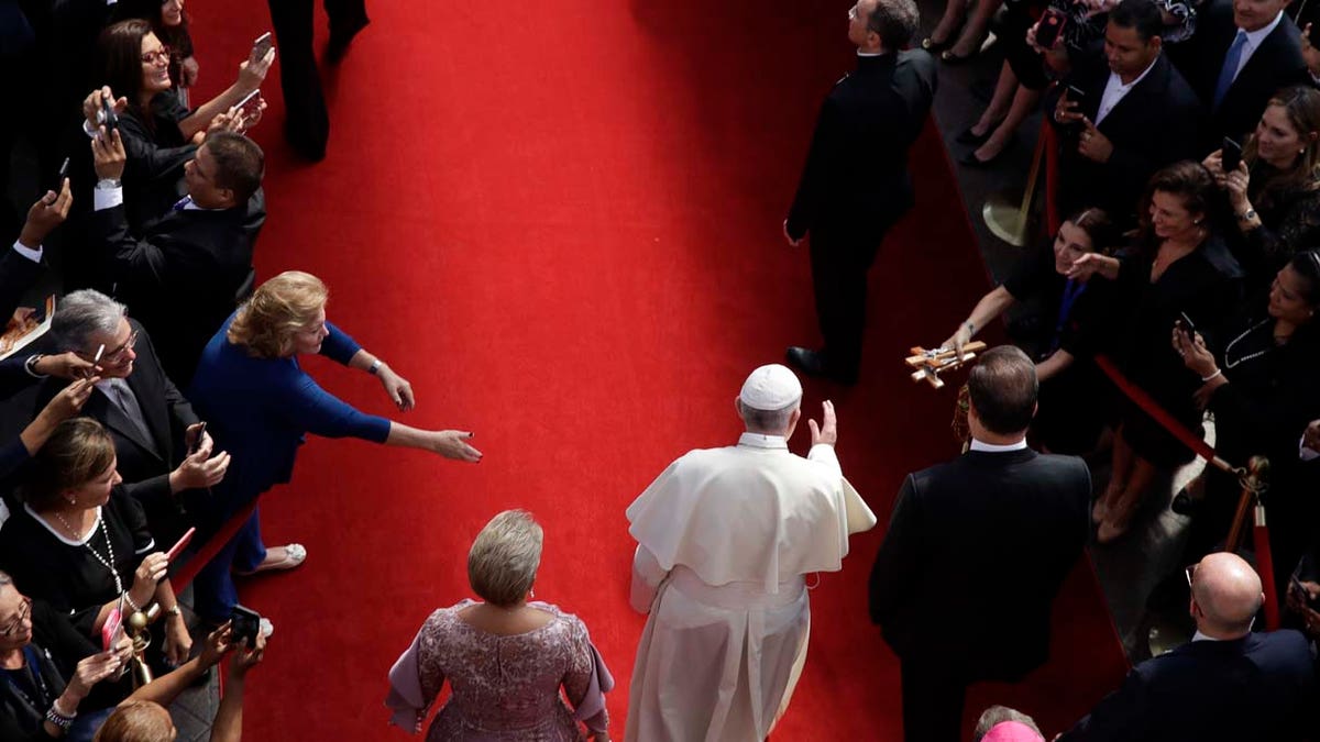 Flanked by Panama's President Juan Carlos Varela, right, and first lady Lorena Castillo, Pope Francis arrives at the foreign ministry headquarters Palacio Bolivar, in Panama City, Thursday, Jan. 24, 2019. (AP Photo/Alessandra Tarantino)