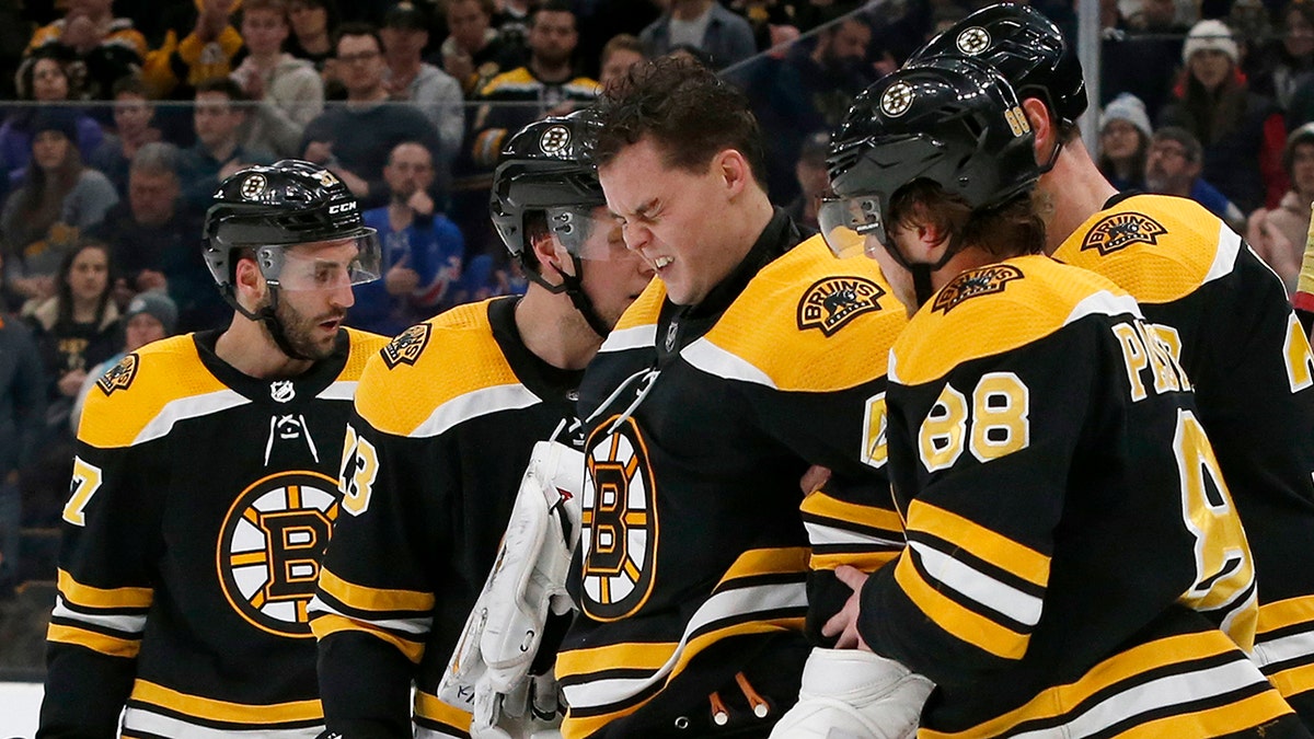 Boston Bruins goaltender Tuukka Rask (40) is helped off the ice after taking a hit on a goal by New York Rangers center Filip Chytil during the first period of an NHL hockey game, Saturday, Jan. 19, 2019, in Boston. (Associated Press)