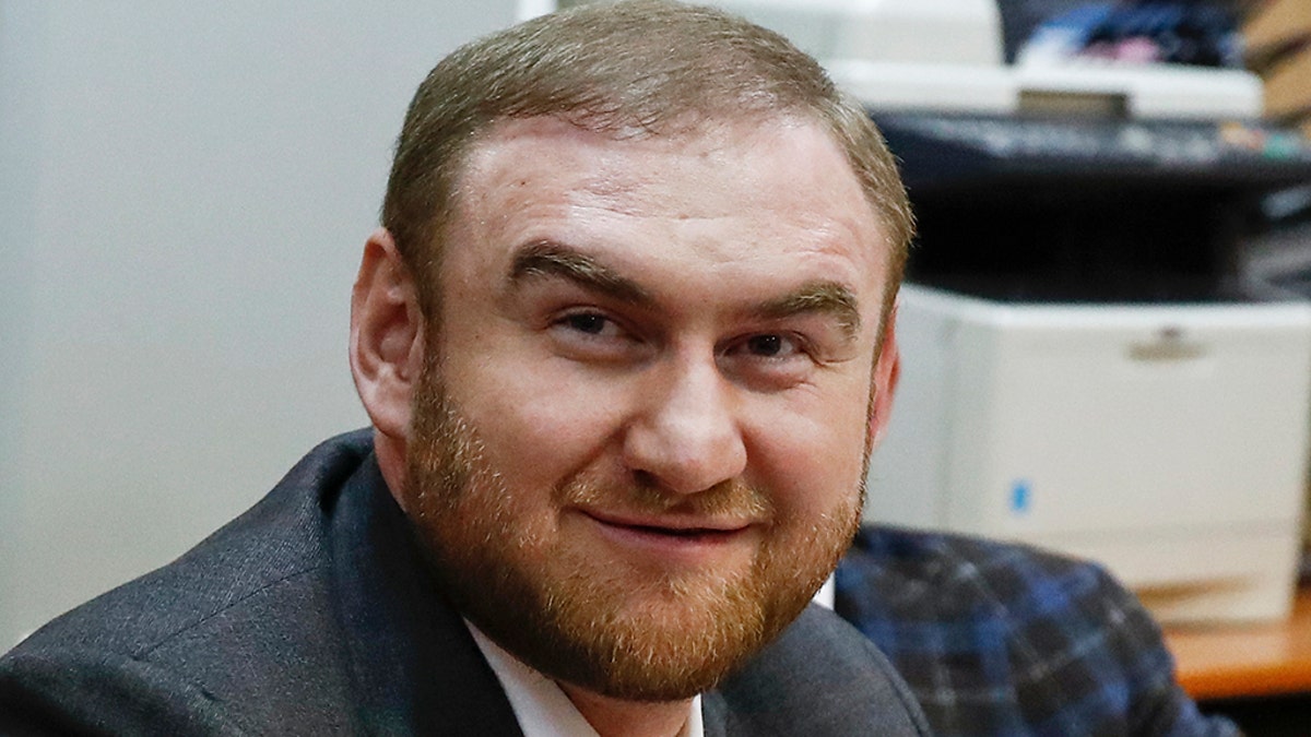 Russian lawmaker Rauf Arashukov smiles during hearings in a court in Moscow Wednesday. The Investigative Committee said  Arashukov, who represents the Karachay-Cherkessiya region in the North Caucasus, was detained after the Federation Council, the upper chamber of the Russian parliament, voted to strip him of immunity from prosecution. Investigators suspect he had a role in orchestrating the killing of two high-profile figures in 2010. (AP Photo/Alexei Morozov)