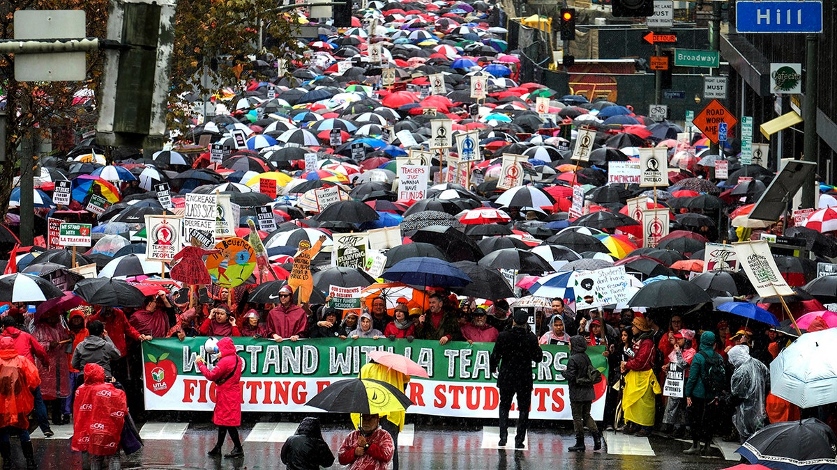 Thousands of teachers and supporters are seen holding signs in the rain during a rally Monday, Jan. 14, 2019, in Los Angeles.