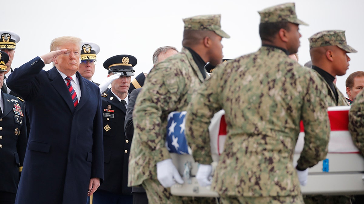 President Donald Trump salutes as a military honor guard carries the remains of Scott Wirtz, a civilian employee of the U.S. Defense Intelligence Agency killed along with three members of the U.S. military during a recent attack in Syria, past during a dignified transfer ceremony at Dover Air Force Base, in Dover, Delaware, U.S., January 19, 2019. REUTERS/Carlos Barria - RC18A626C300