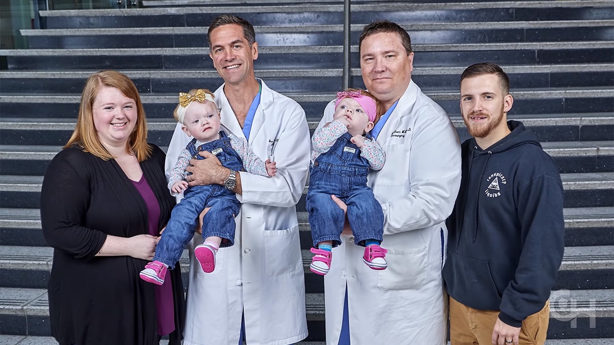 The twins, now over 2 years old and pictured here with their surgeons and parents, have started babbling and are involved in physical, developmental and speech therapies.?