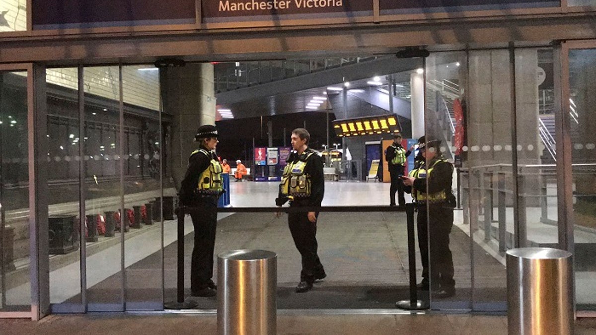 Police at Victoria Station in Manchester, England, late Monday Dec. 31, 2018 after a man had stabbed three people.