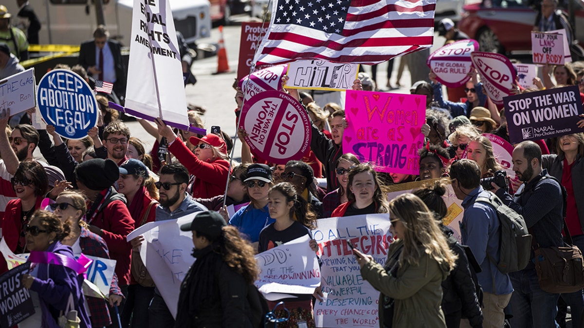 Women in red march from Freedom Plaza to the White House during a Day Without a Woman protest in Washington, USA on March 8, 2017. (Photo by Samuel Corum/Anadolu Agency/Getty Images)