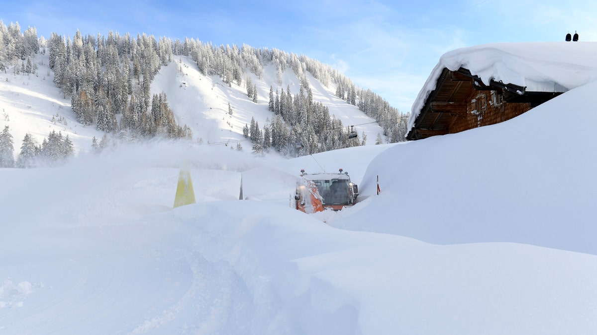 A snow blower works on a road at the Loferer Alp, Austrian province of Salzburg, Friday, Jan. 11, 2019.