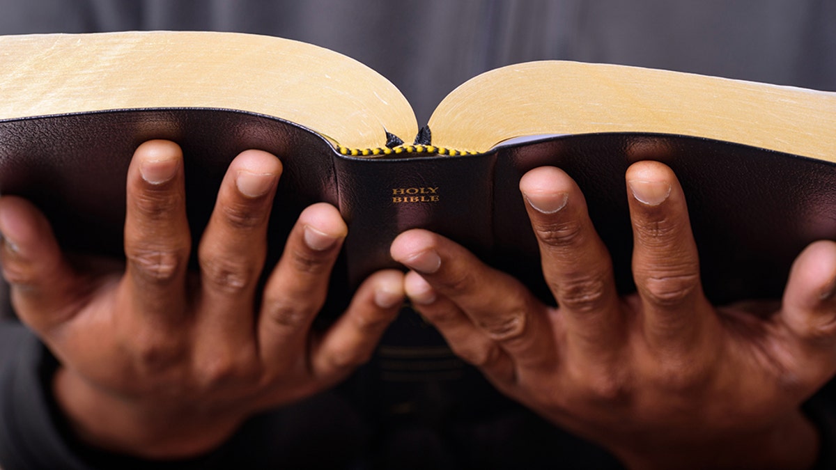 A close up view of a man hands holding the Holy Bible, Worship Concept