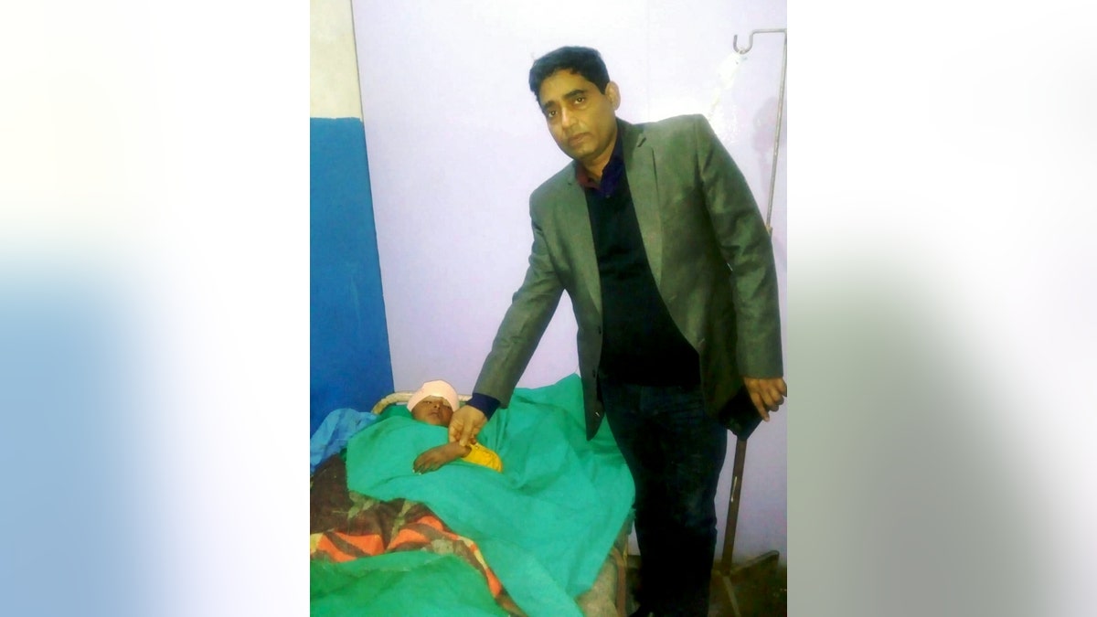 Dr. Chandra, pictured with Chhabila, said a CT scan revealed the bolt stopped just millimeters from the boy's brain.