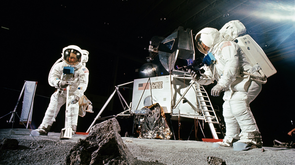 Buzz Aldrin, on the left, practices scooping up a sample while Neil Armstrong, on the right, photographs the collection, during a practice session held before the Apollo 11 mission.