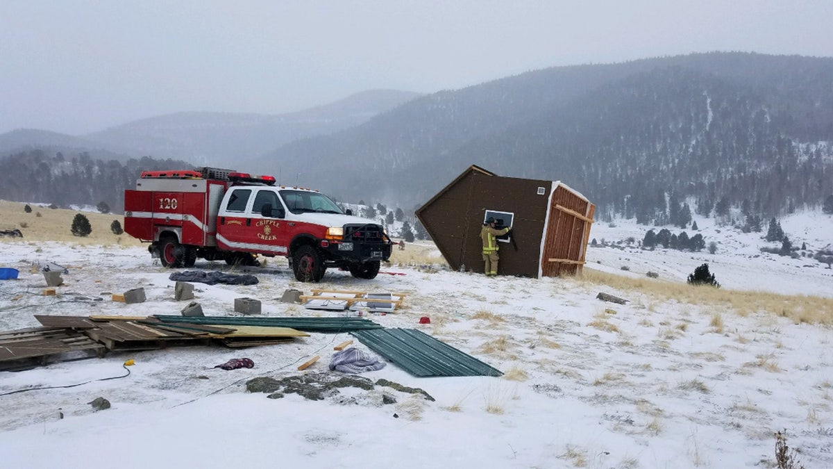 A woman and two cats were inside the tiny house when it was blown away by fierce winds, according to fire officials.