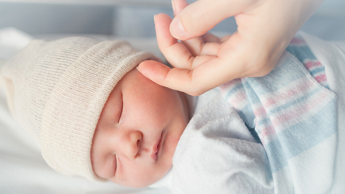 Baby sleeping wearing a cap