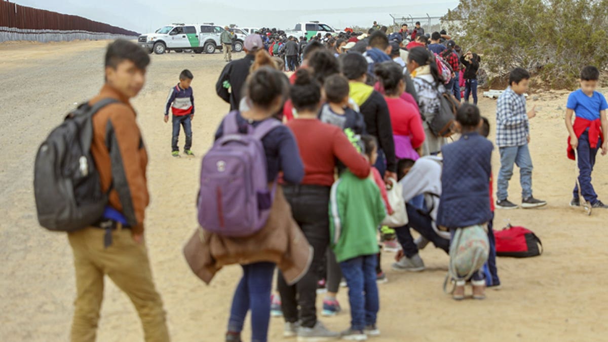 This Monday, Jan. 14, 2019 photo released by U.S. Customs and Border Protection shows some of 376 Central Americans the Border Patrol says it arrested in southwest Arizona, the vast majority of them families, who used short holes dug under a barrier to cross the border in multiple spots about 10 miles east of San Luis, Ariz. The unusually large group was almost entirely from Guatemala.