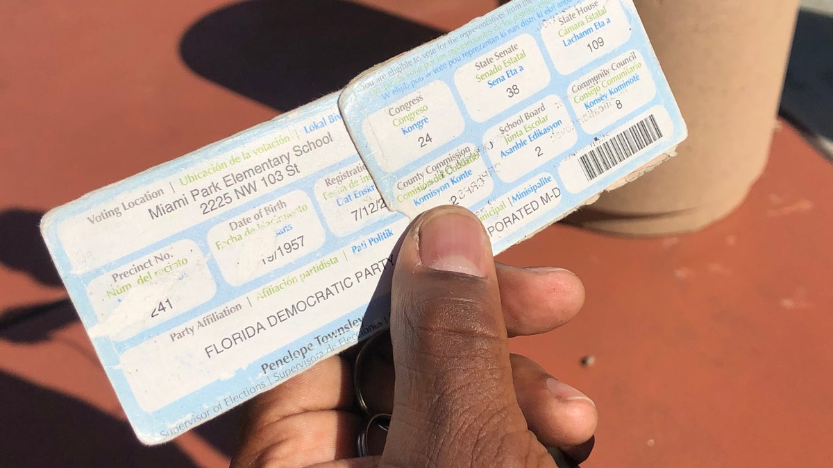 Ex-convicts show their former voting cards, before they lost their right to vote.