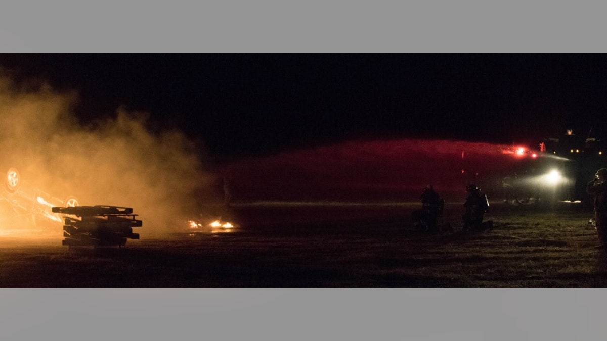 Massachusetts National Guard soldiers with the 79th Engineer Company (Firefighting) hose down a car fire during a training exercise at Tactical Training Base Kelly, Joint Base Cape Cod, Massachusetts on June 9th, 2018.