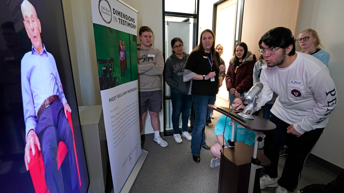 Matthew Rosca-Halmagean, 17, right, a student at Westchester Academy for International Studies, asks a question to Holocaust survivor William Morgan using an interactive virtual conversation exhibit at the the Holocaust Museum Houston Friday, Jan. 11, 2019, in Houston. (AP Photo/David J. Phillip)