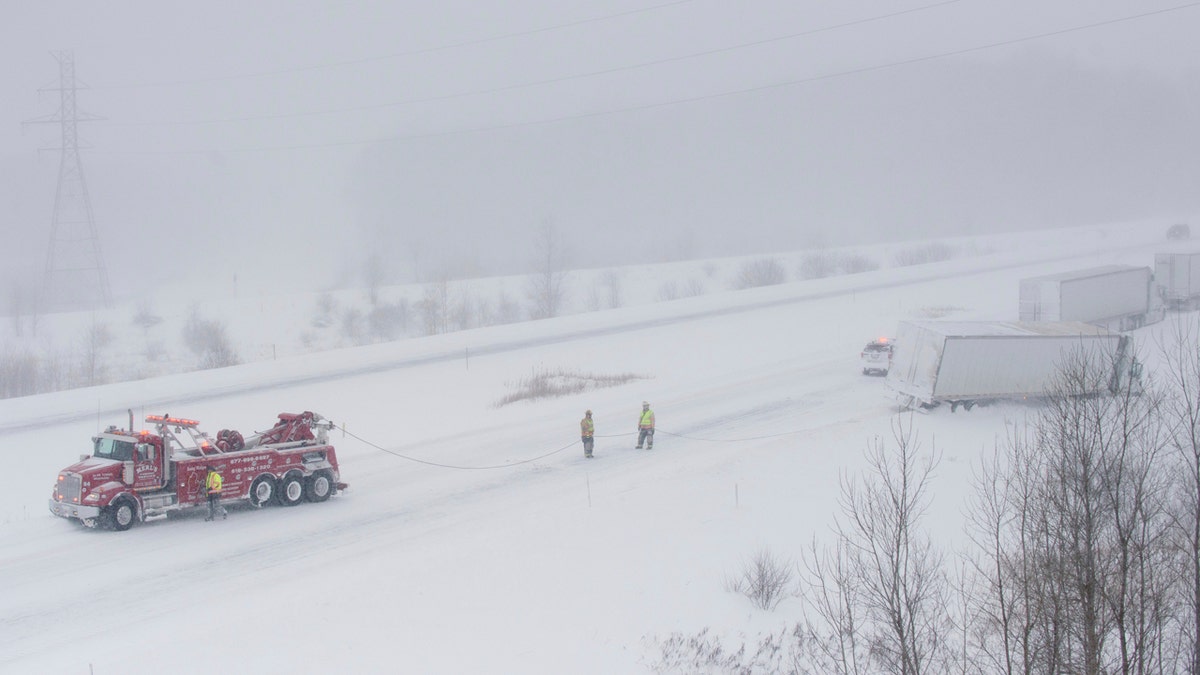 A Merl's Towing Service truck pulls a semi-trailer truck out of the snow along M-6 near exit 1 near Grandville on Wednesday, Jan. 30, 2019. Subzero temperatures were recorded across the area.