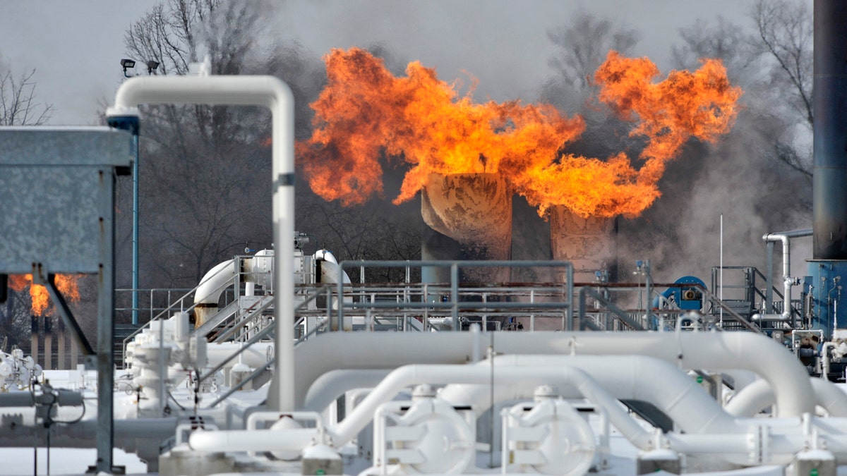 Fire comes out of the top of two silo-looking structures at the compressor station at Consumers Energy in Armada Township, Mich. Consumers Energy has called on customers to voluntarily reduce their natural gas usage following a fire at a suburban Detroit gas compressor station amid bitterly cold weather.