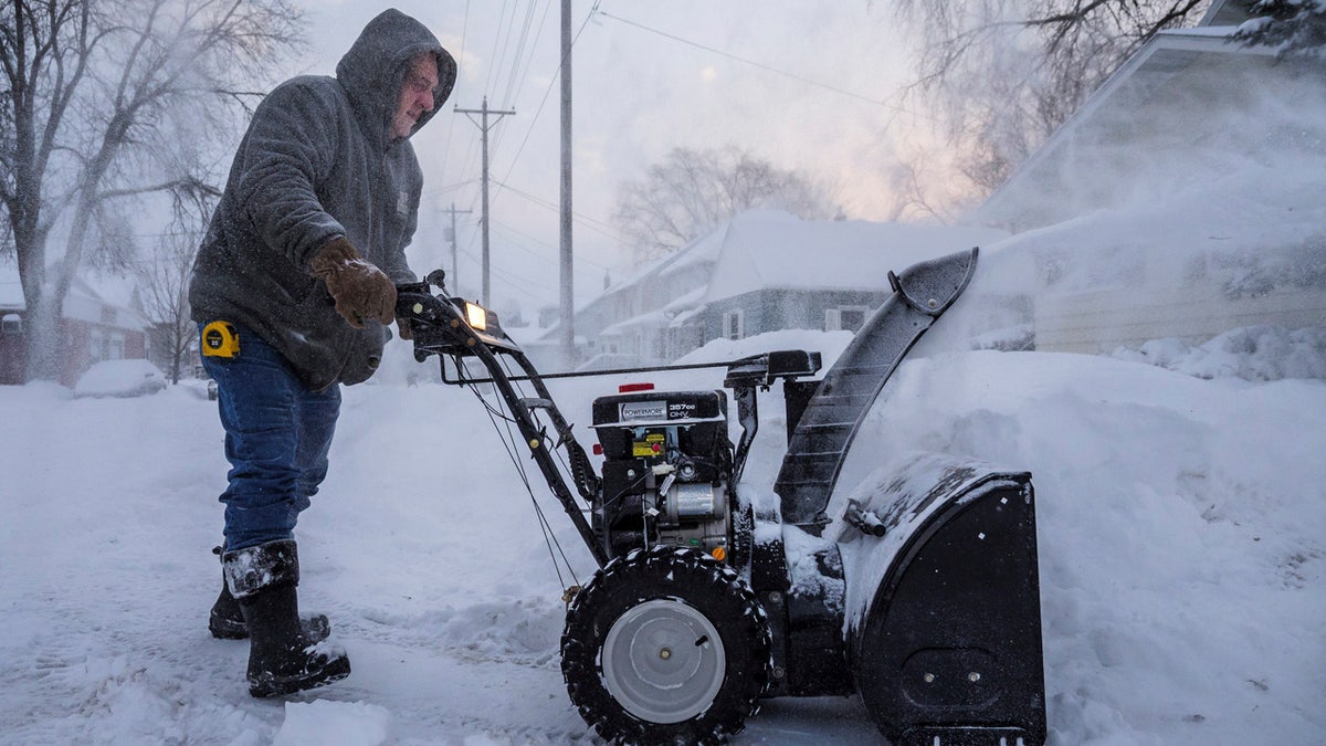Mike Johnson snow blows his driveway Monday, Jan. 28, 2019, in Rochester, Minn.