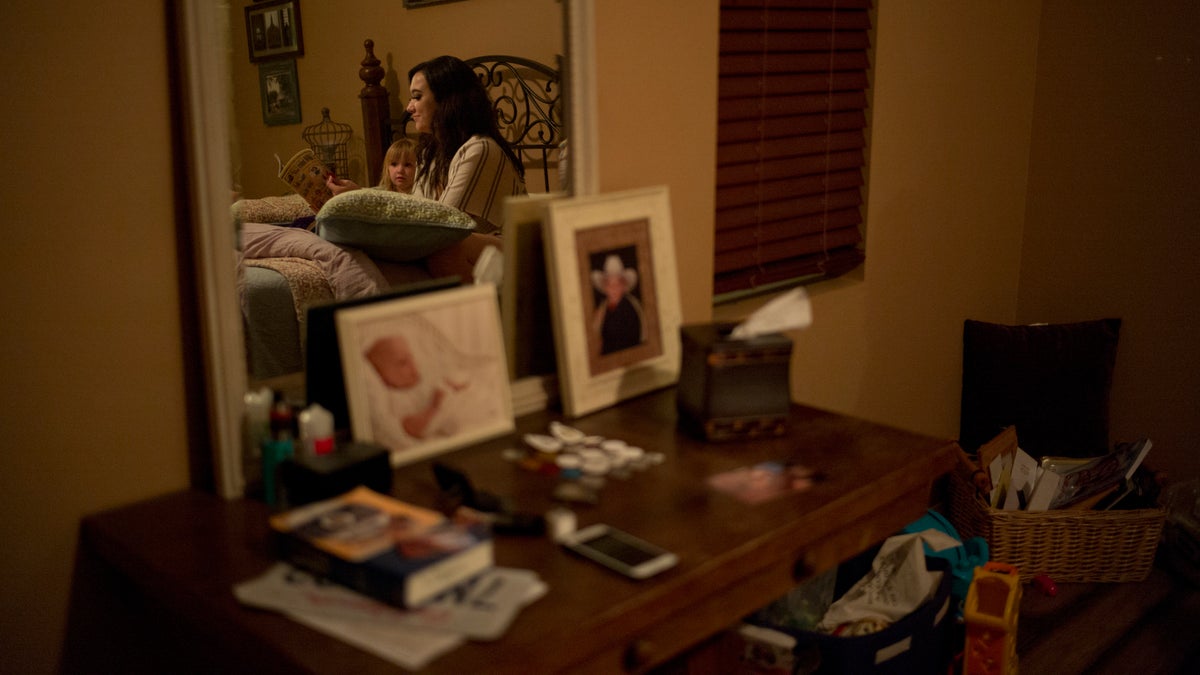 Landon Biggers' longtime girlfriend, Megan Dealbert, reads a bedtime story to their daughter, Aubrey, in La Quinta, Calif.