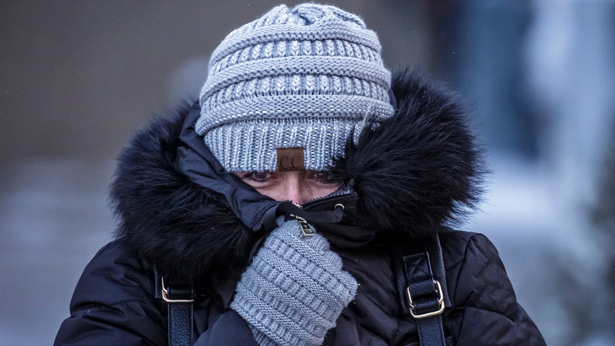 Andrea Billings keeps her face covered while walking across Center Street at its intersection with 1st Avenue in subzero temperatures on the way to her car after work Tuesday, Jan. 29, 2019, in downtown Rochester, Minn.