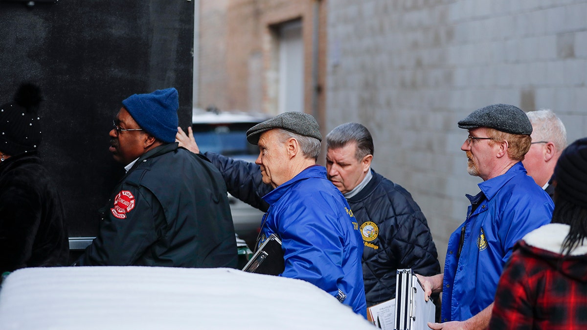 City inspectors from the Department of Buildings and the Chicago Fire Department enter from the back door alley entrance to the studio space for musician R. Kelly in Chicago on Jan. 16, 2019. A judge says a Chicago warehouse that R. Kelly is renting can be used only between 9 a.m. and 5 p.m. and only as a recording studio. The Chicago Sun-Times says the Cook County judge also prohibited use of the second floor Tuesday, Jan. 22, 2019, after building inspectors found faulty stairs. (Jose M. Osorio/Chicago Tribune via AP)